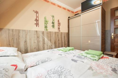 a bedroom with a large bed with green pillows on it at Valentin Deluxe Apartman in Hajdúszoboszló
