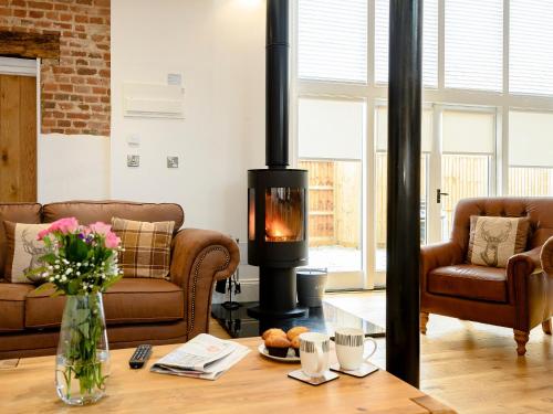 a living room with a wood stove in a room at Pipistrelle Barn in North Walsham
