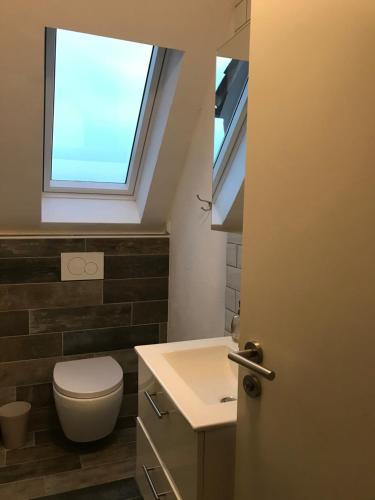ein Bad mit einem WC und einem Fenster in der Unterkunft Sonnenblick in Bad Nenndorf
