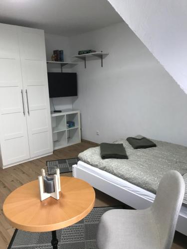 a small bedroom with a bed and a table at Sonnenblick in Bad Nenndorf