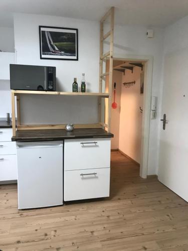 a kitchen with white cabinets and a microwave at Sonnenblick in Bad Nenndorf
