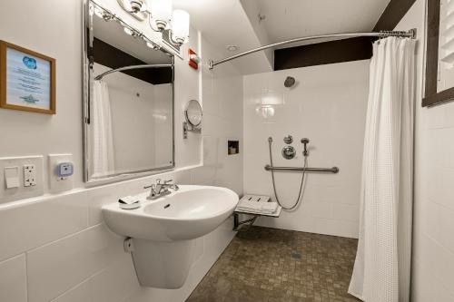 a white bathroom with a sink and a shower at El Pueblo Inn in Sonoma