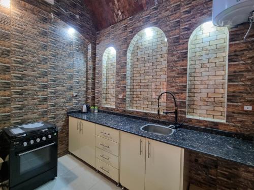 uma cozinha com um lavatório e uma parede de tijolos em Anwar GuestHouse em Luxor
