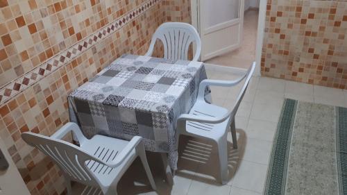 a table with two chairs and a table with a checkered at Appartement bord de mer à Nabeul in Nabeul