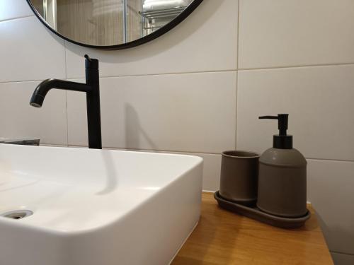 a bathroom sink with a soap dispenser and a mirror at אתיטיוד בערבה attitude at the arava in H̱aẕeva