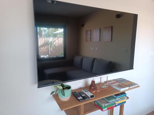 a large flat screen tv hanging on a wall at אתיטיוד בערבה attitude at the arava in H̱aẕeva