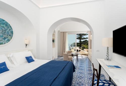 um quarto de hotel com uma cama e uma televisão em La Vega em Capri