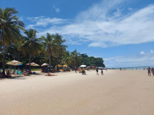 un gruppo di persone su una spiaggia con palme di Cantim a Santa Cruz Cabrália