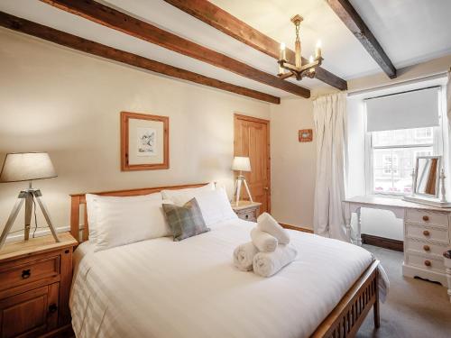 a bedroom with a bed with two teddy bears on it at Well House in Belford