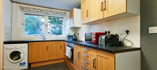 a kitchen with a sink and a washing machine at Clapham Garden near Battersea Park in London