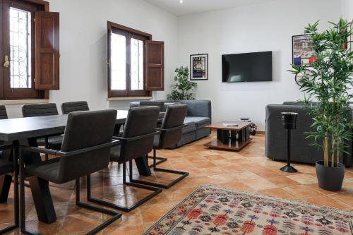 una sala conferenze con tavolo, sedie e TV a schermo piatto di GoodStay Central Suite -Terrace & Charme- a Lecce