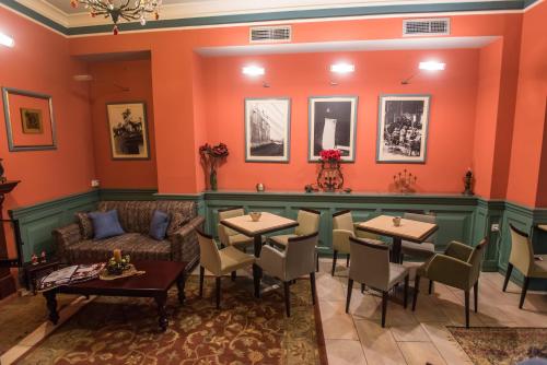 a restaurant with tables and chairs and a couch at City Hotel Apollonion in Karpenision