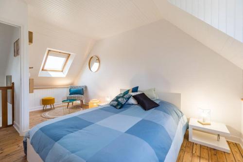 una camera da letto con un grande letto blu in mansarda di Paradis côtier - Maison vue mer à Loguivy a Ploubazlanec
