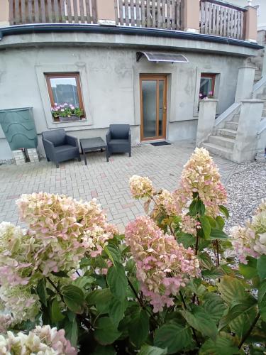 a patio with a table and chairs and flowers at Nový byt Liberec 30 in Liberec