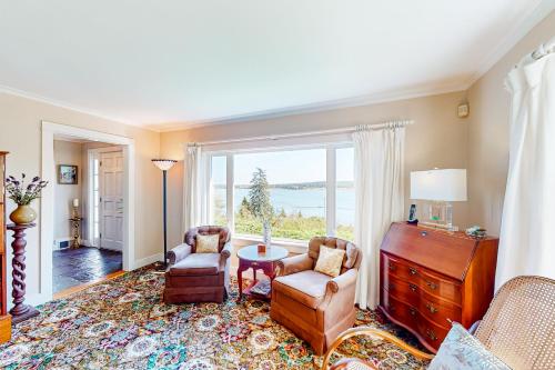 a living room with a table and chairs and a large window at Pigeon Hill Retreat in Steuben