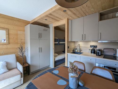 - une cuisine et un salon avec une table dans une petite maison dans l'établissement Appartement rénové 2023 au centre de La Clusaz avec balcon, garage, et accès facile aux pistes - FR-1-459-178, à La Clusaz