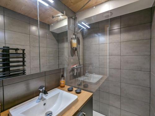 une salle de bain avec un lavabo et un miroir dans l'établissement Appartement rénové 2023 au centre de La Clusaz avec balcon, garage, et accès facile aux pistes - FR-1-459-178, à La Clusaz