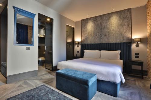 得利雅斯特的住宿－FORVM bijoux ROOMS，一间卧室设有一张大床和一张蓝色凳子