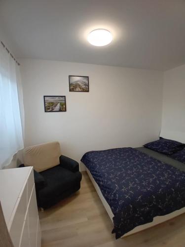 a small bedroom with a bed and a chair at Nový byt Liberec 30 in Liberec