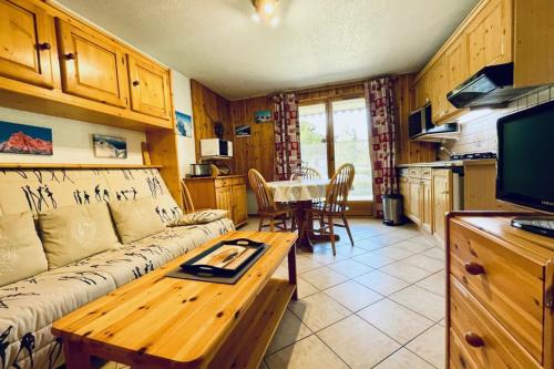 ein Wohnzimmer mit einem Sofa und einem Tisch in der Unterkunft Eden des Houches Furnished flat in Les Houches