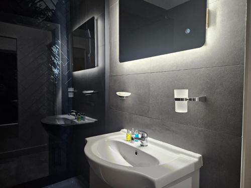 een badkamer met een witte wastafel en een spiegel bij Centenary Apartments in Bradford