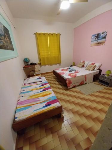 a bedroom with two beds and a wooden floor at BIENVENUE AU SOLEIL LEVANT assier entrée morne savon ,le lorrain in Le Lorrain