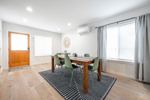 ein Esszimmer mit einem Holztisch und grünen Stühlen in der Unterkunft Ballard Home Base - Comfy Modern House in Seattle in Seattle
