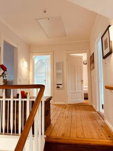 a hallway with a wooden floor and stairs in a house at Villa am Strand in Eckernförde