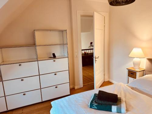 a bedroom with a white dresser and a bed at Villa am Strand in Eckernförde
