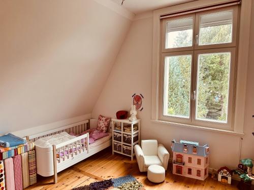 a baby room with a crib and a window at Villa am Strand in Eckernförde