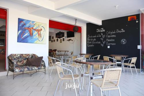 a restaurant with tables and chairs and a chalkboard on the wall at Pousada Ju&Ju à 400 mts DA PRAIA in Pontal do Paraná