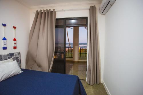 Schlafzimmer mit einem Bett und einer Glasschiebetür in der Unterkunft Maravilhosa casa em Vilas do Atlantico frente ao mar in Lauro de Freitas