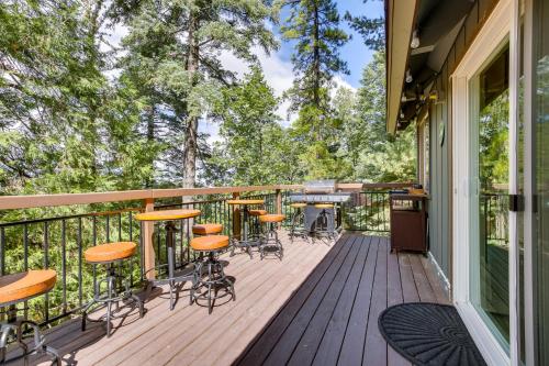 a deck with bar stools and a grill at Cozy and Chic Lake Arrowhead Cabin with Deck! in Lake Arrowhead