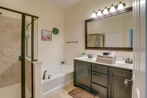 a bathroom with a tub and a sink and a mirror at Covered Patio and Large yard Mansfield Home in Mansfield