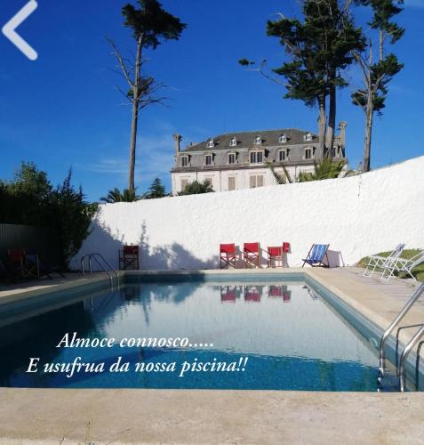 a house with a swimming pool in front of a white wall at Boutique Inn & Restaurant - Casa dos Suécos in Figueira da Foz