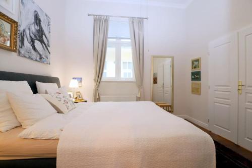 una camera da letto con un grande letto bianco e una finestra di Hidden gem - Cozy quiet 2BR apt in city center a Bratislava