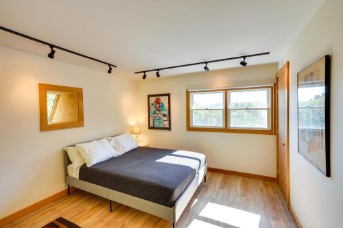 1 dormitorio con 1 cama y 2 ventanas en Charming Claverack Retreat with Serene Deck! en Claverack