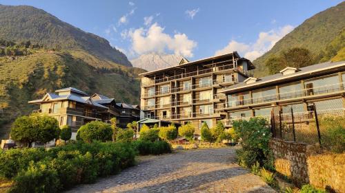 um hotel nas montanhas ao lado de uma estrada em Great Empire Hotel em Dharamshala