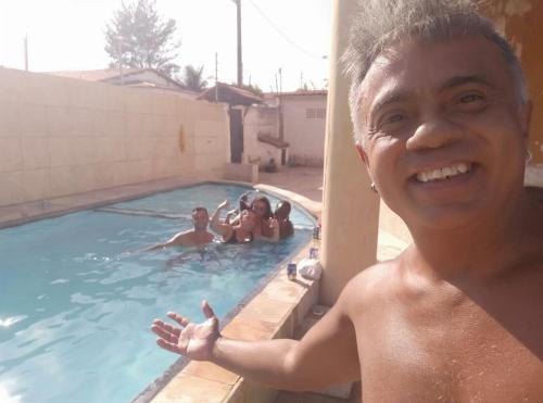 a man is standing in a swimming pool at Pousada e Hostel Lua de Tomate in Caucaia