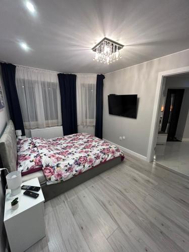 a bedroom with a bed and a chandelier at Apartament Jodłowa in Kołobrzeg