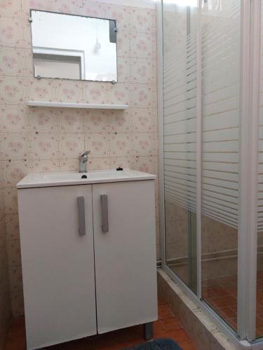 uma casa de banho com um lavatório e um espelho em LE RELAIS DES 4 b-SAISONNIER em Le Gosier