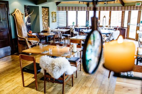 a restaurant with tables and chairs and a mirror at The Cock and Bull in Balmedie