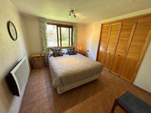 a bedroom with a bed and a television in it at Casa Foresta Melipillán - Melipilla in Melipilla