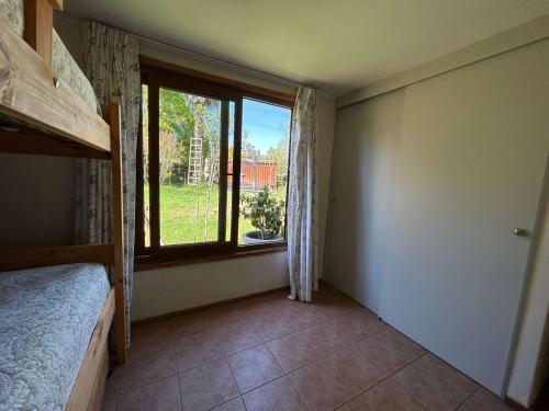 a bedroom with a bed and a large window at Casa Foresta - BBQ Cocina Piscina Mascota Wifi in Melipilla