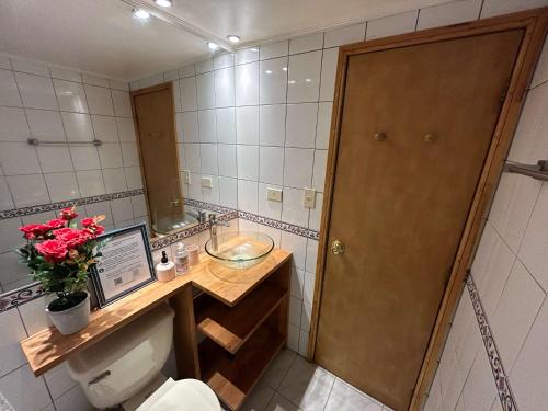 a bathroom with a toilet and a sink and a mirror at Casa Foresta - BBQ Cocina Piscina Mascota Wifi in Melipilla