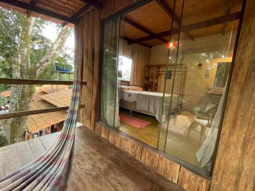 a hammock in a room with a view of a bedroom at Vila Amor - Charmosa e Central in Alto Paraíso de Goiás