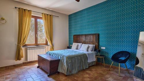1 dormitorio con cama y pared azul en Villa Strognano, en Cerreto Guidi