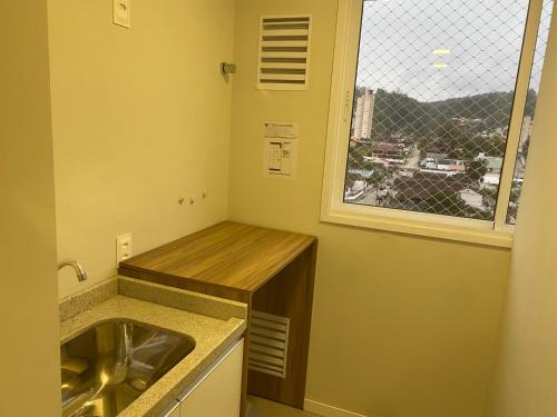 a small kitchen with a sink and a window at House Park completo em Blumenau-SC in Blumenau