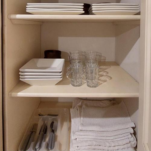 a cabinet with plates and glasses on a shelf at Altos H in Santiago del Estero