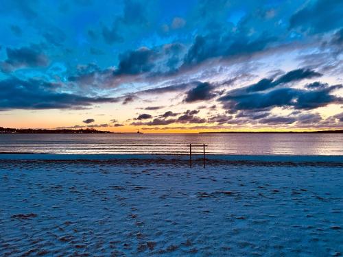 a view of a beach with a sunset in the background at Villa am Strand in Eckernförde